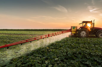 Tractor spraying a vegetable field in the spring.