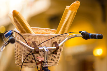 A basket with fresh goods on a bicycle.