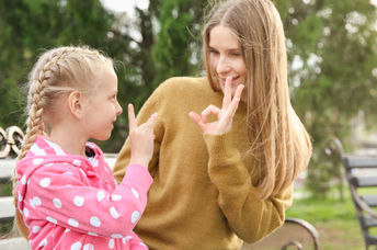 A woman and her daughter sign together using ASL.
