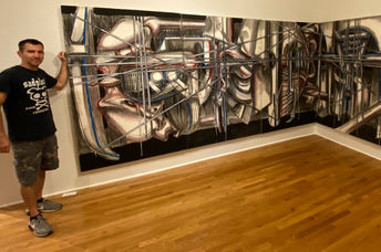 Jared Whipple stands in a gallery beside a Frances Hines painting.