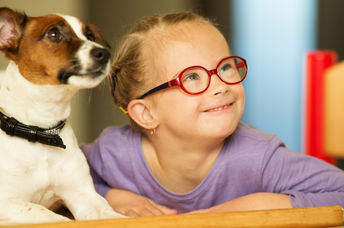 Cute girl learning with the help of a friendly dog.