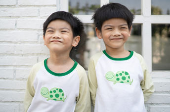 Smiling Asian twin boys.