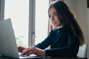 A young woman sitting with her laptop.