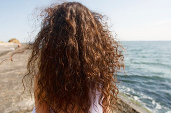 Young woman with long hair at the beach.