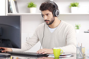 A young man sitting with headphones.