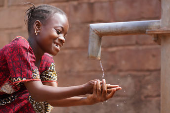 An African boy washing his hands.