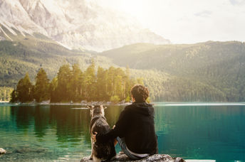 Man sitting with his dog in nature.
