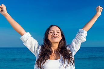 Happy woman by the beach.
