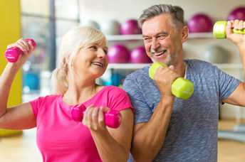 A mature couple lifts weights together, a workout for the body and mind.