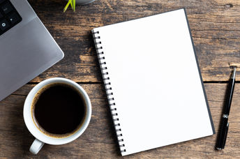 An empty notebook and a computer.