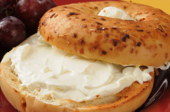 An onion bagel with a smear of plant-based vegan cream cheese.