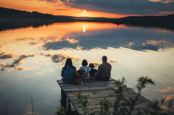 A family sitting on a bridge.