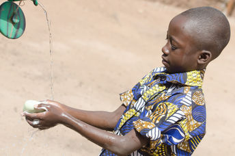 A boy washing his hands.