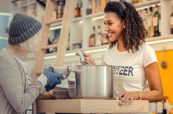A volunteer giving soup to the homeless.