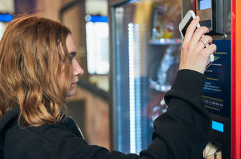 Women using a conventional vending machine at work