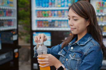 Woman purchasing a beverage from a vending machine.