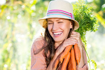 Woman with some just-picked organic carrots.