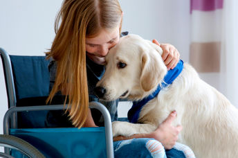 Young woman in a wheelchair with her service dog.