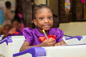 Smiling African child in her classroom.