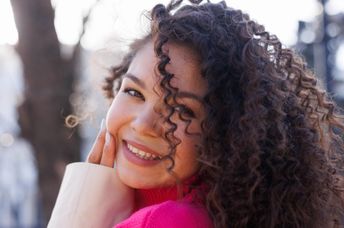 Smiling, young Gen Z woman.