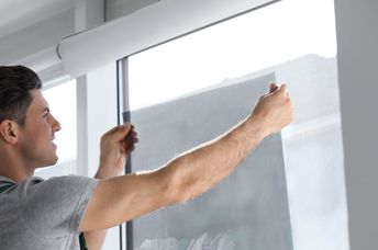 Installing window film to keep the heat out.