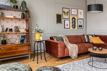 Eclectic living room with a rust-colored sofa.