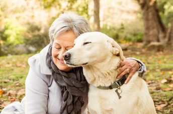 A senior woman cuddling with her dog.
