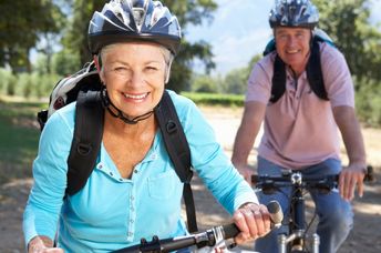 Two healthy seniors riding bikes.