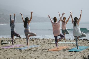 Women doing yoga on the beach.