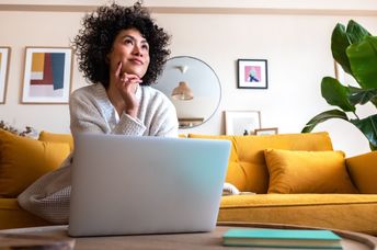 A woman thinking in a living room.