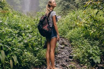 A woman walking barefoot in the forest.