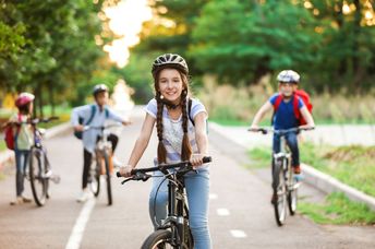 A group of children ride their bicycles.