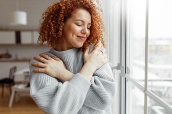 A woman hugs herself.
