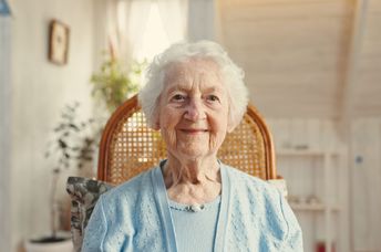 An elderly woman smiles.