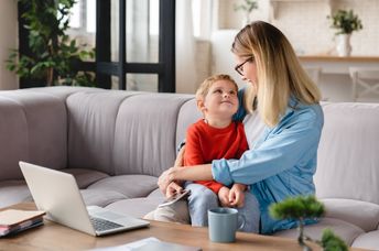 A mother and her child sit on a couch.