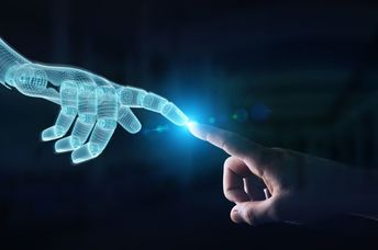 Wireframed robot hand making contact with human hand, depicting AI innovation.