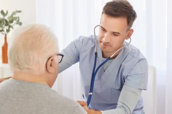 Young doctor examining an elderly patient.