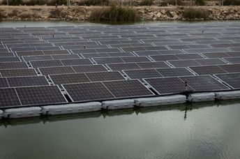 A solar panel system installed above a fish pond.