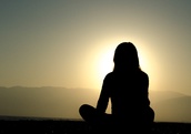 Woman meditating at sunset