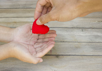 Hand handing over a heart