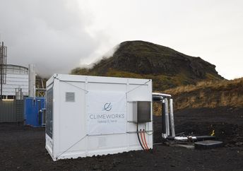 Direct air capture unit along with the cooling towers of the geothermal power plant in Hellisheidi, Iceland.
