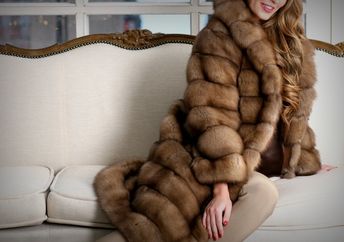 Woman in fur coat, close up, on the sofa, fur texture