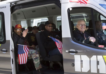 Vets wave the American Flag from the DAV, Disabled American Veterans, van during the 2016 annual America's Parade held on Veterans Day in Manhattan