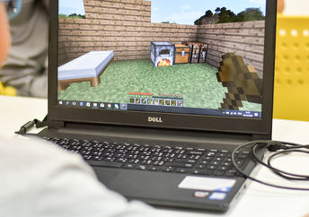 Boy playing Minecraft on PC. Minecraft is a very popular game for all devices.