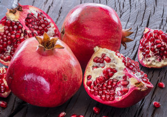 Ripe pomegranate fruit on wooden vintage background.