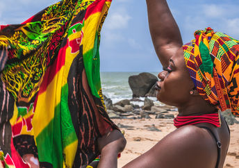 A West African woman holds colorful fabric.
