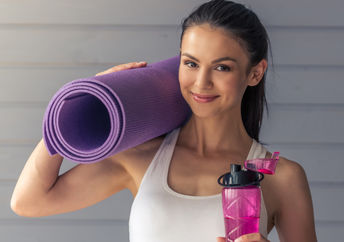 A woman getting ready to begin yoga poses on her yoga mat.