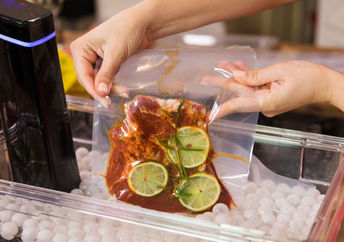 Marinated meat in a vacuum bag and a sous vide cooker.