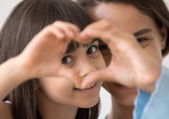 P&G Leads With Love, like this young girl forming a heart with her hands.