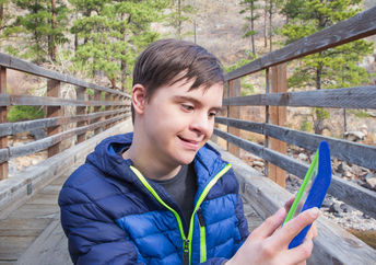 A boy with autism and Down's Syndrome using a tablet app